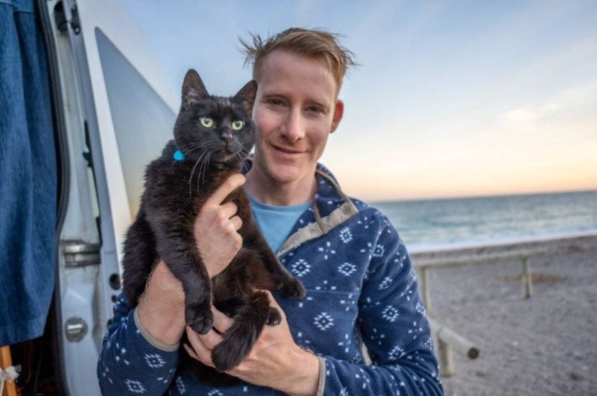 Katze und ihr Besitzer am Strand