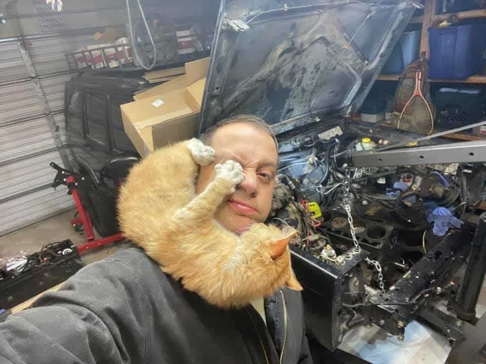 Mann mit Katze in der Garage