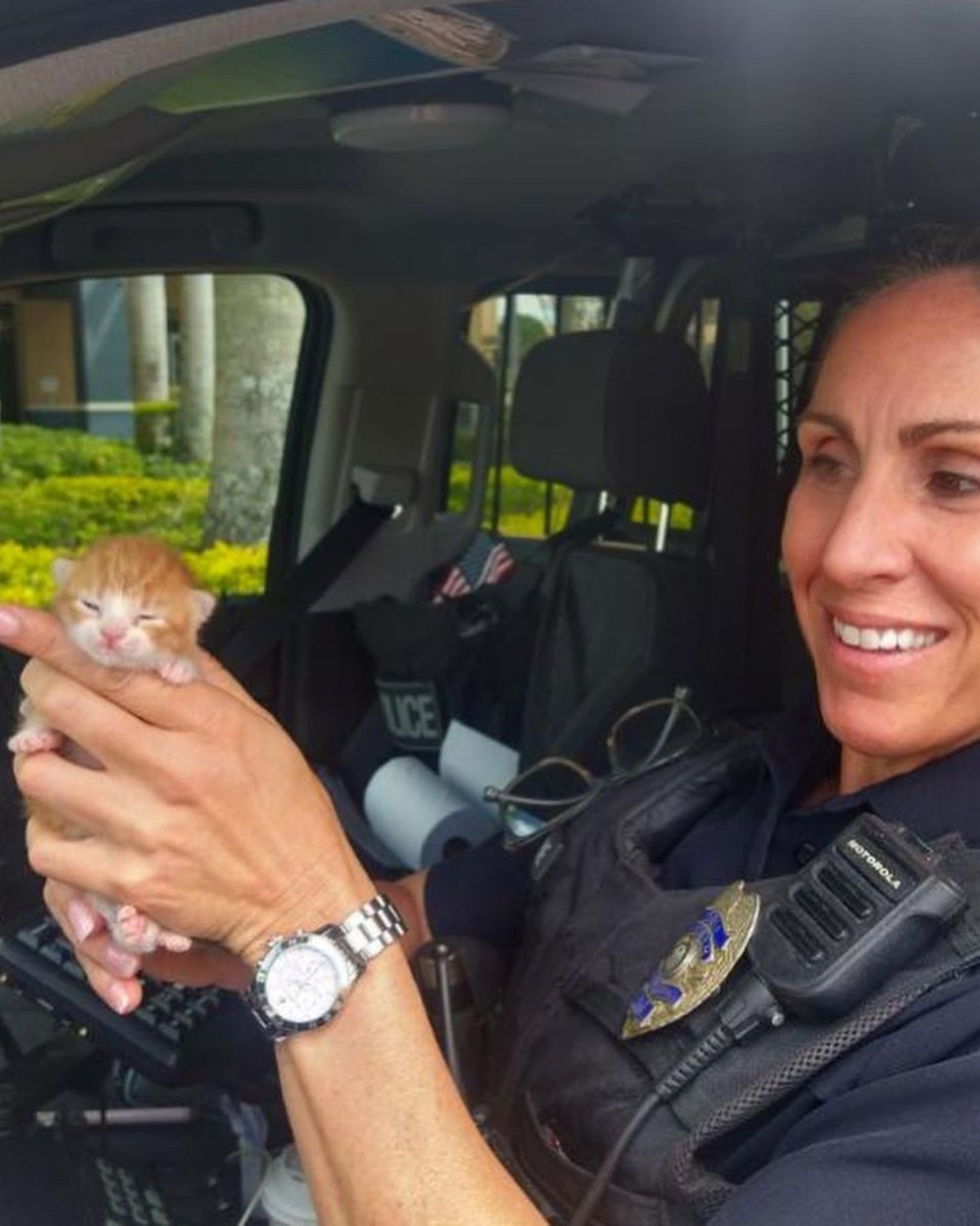 Polizistin mit einem Katzenbaby in der Hand